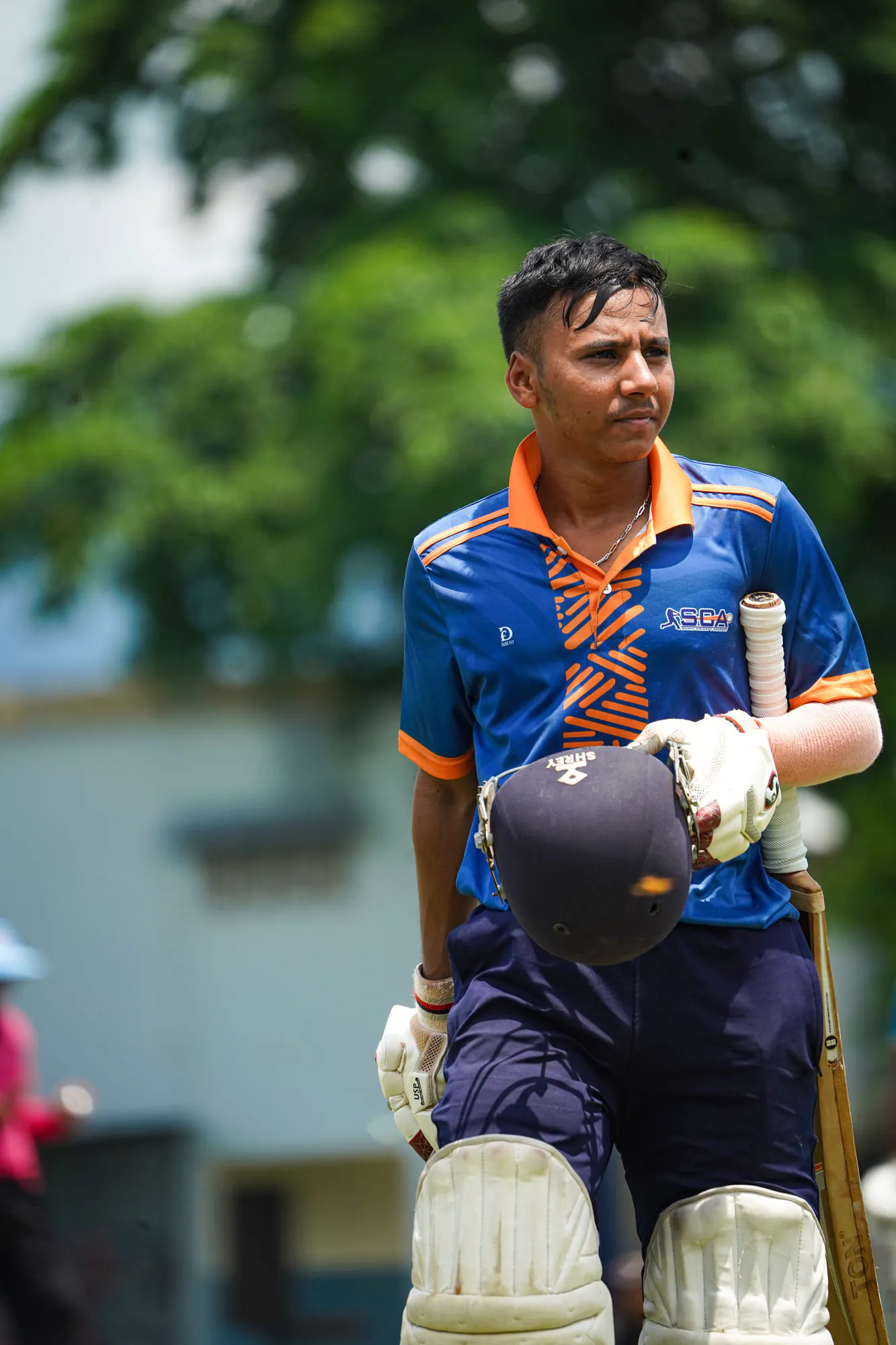 An SCA batter walking off with helmet and bat in hand