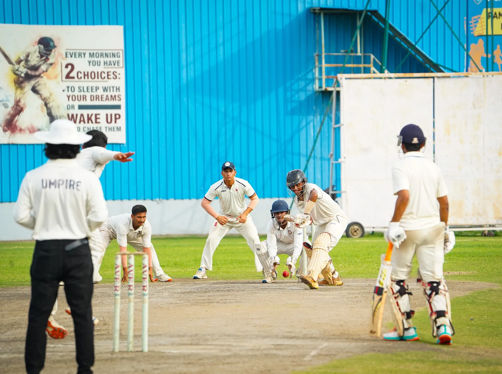 A batter sweeping with close fielders crowded around the bat