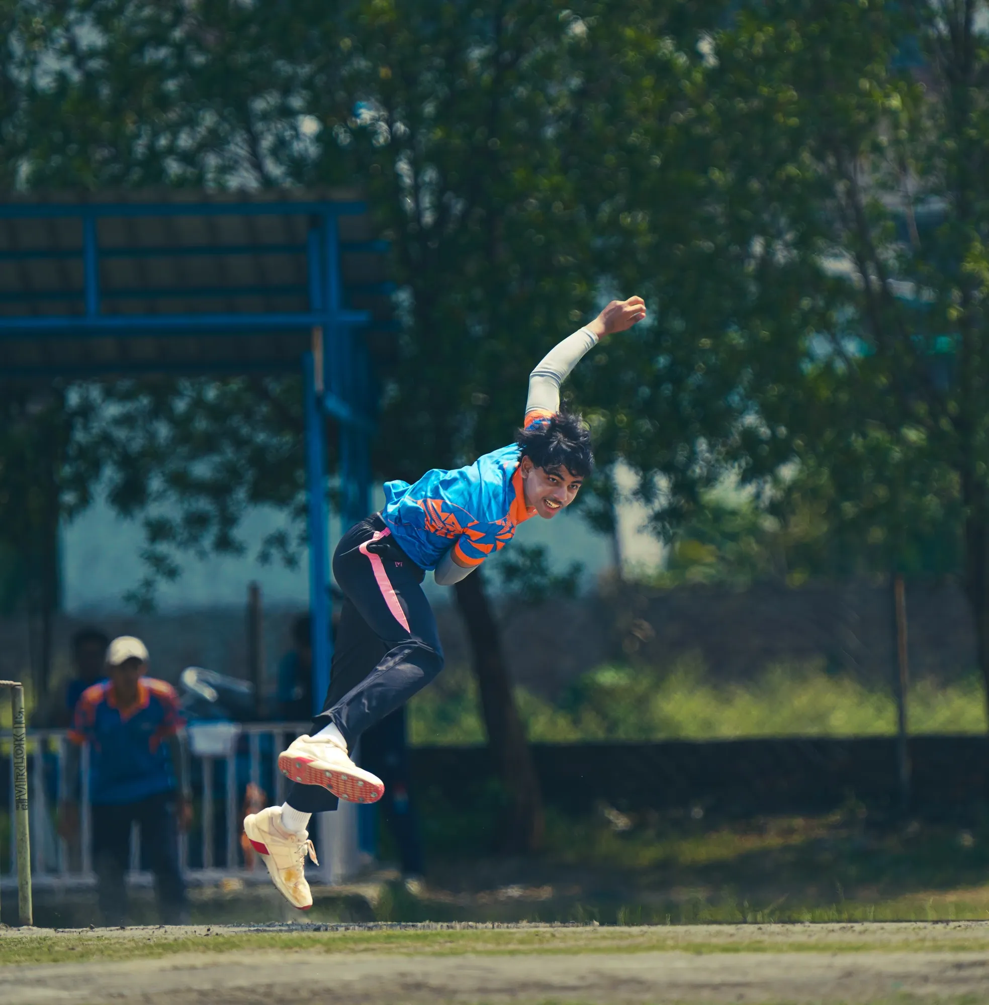 An SCA bowler airborne in his delivery stride