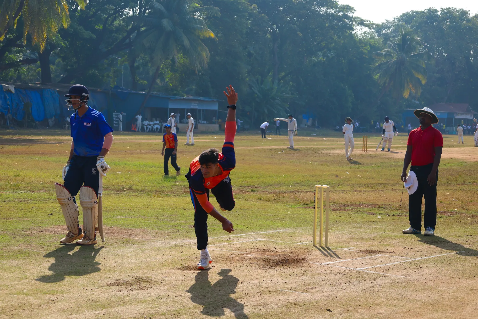 A bowler in his follow-through during a match on the maidan