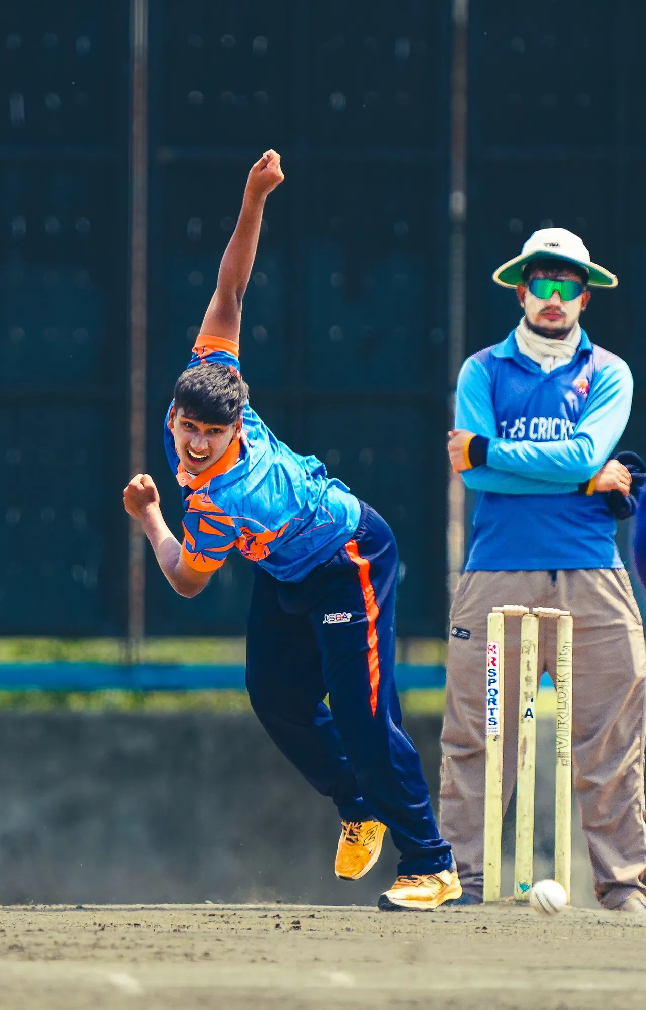 An SCA bowler in his follow-through beside the umpire