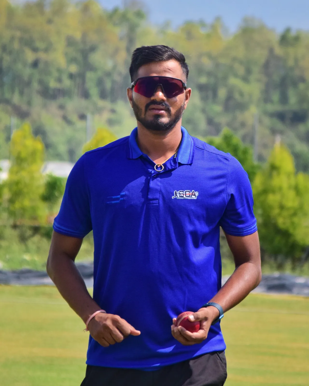 Mr. Sunil Soni, Founder and Director of Sunil Cricket Academy, holding a cricket ball on the ground