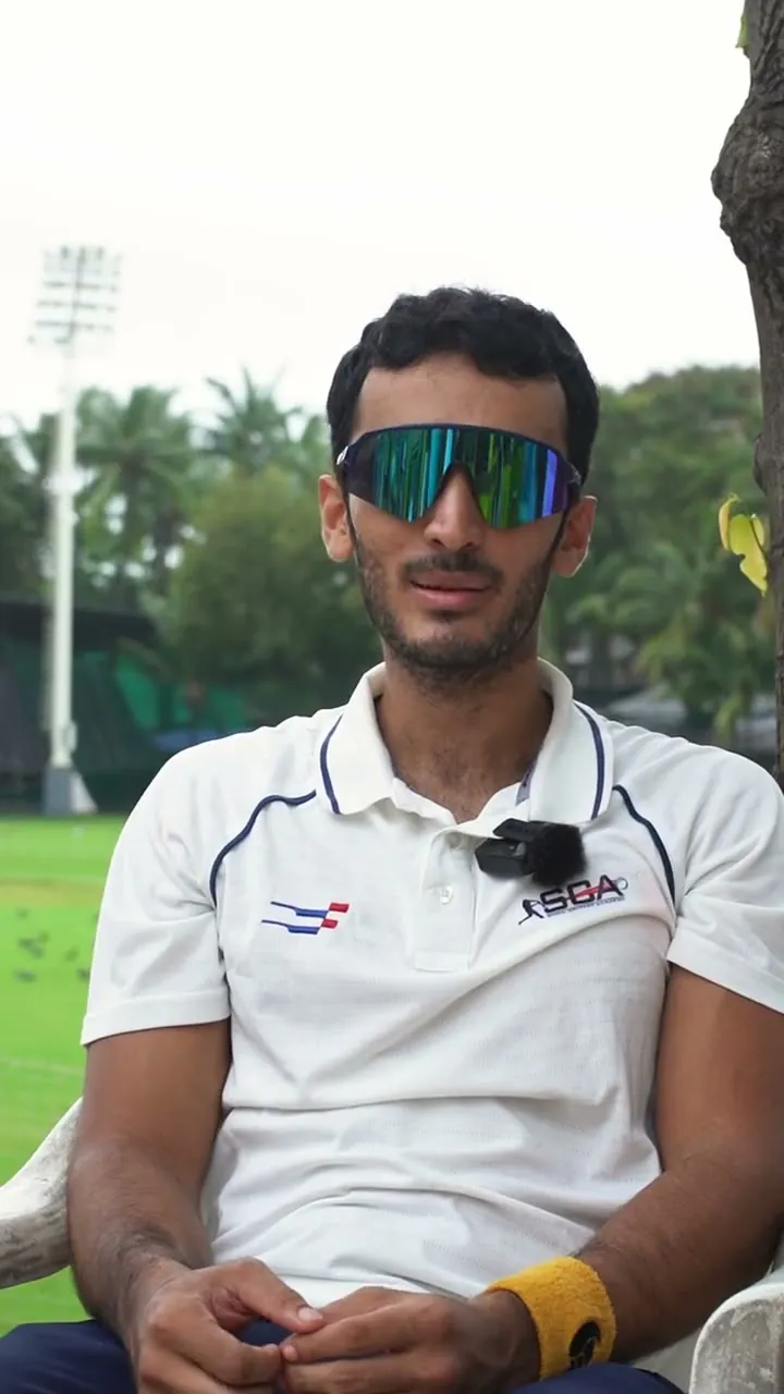 Al-Saad Shaikh in an SCA shirt and sports sunglasses, seated beside the ground.