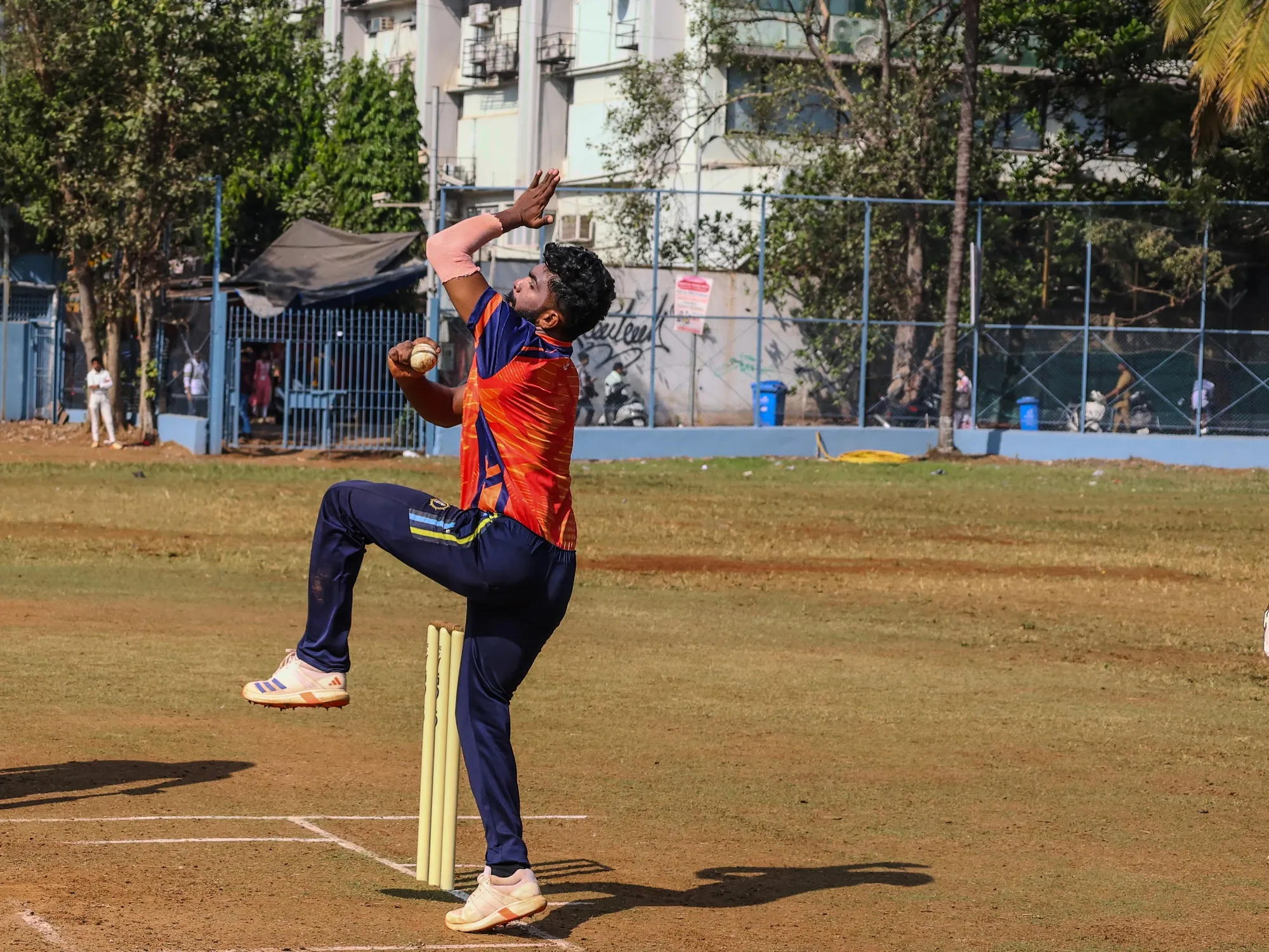 A bowler loading up at the crease, seen front on